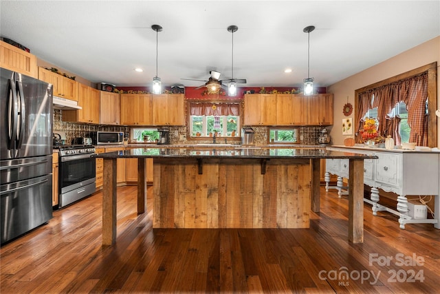 kitchen featuring pendant lighting, light hardwood / wood-style flooring, and stainless steel appliances