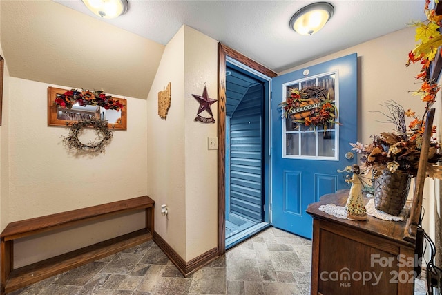 foyer entrance with a textured ceiling