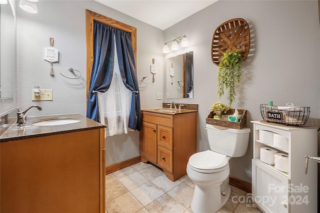 bathroom with vanity, toilet, and tile patterned floors