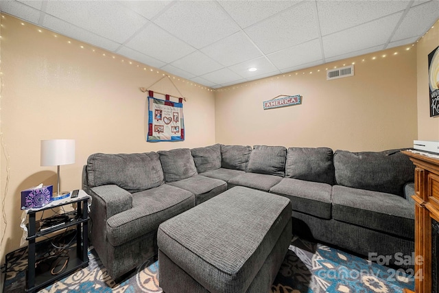 living room featuring a paneled ceiling and carpet flooring