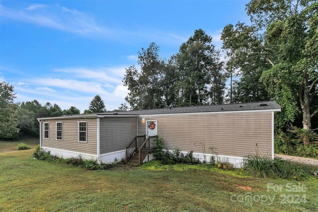 rear view of property featuring a lawn