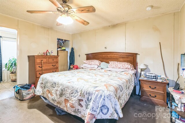 bedroom featuring ceiling fan and a textured ceiling