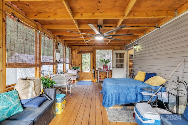 unfurnished sunroom featuring beamed ceiling and ceiling fan