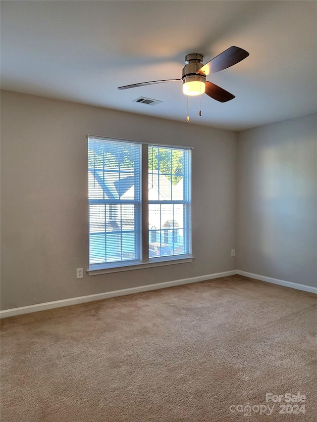 unfurnished room with ceiling fan and carpet