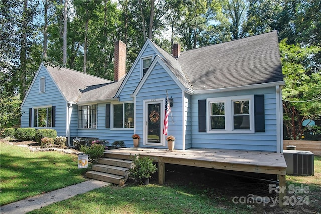 view of front of property featuring a wooden deck, central AC, and a front lawn