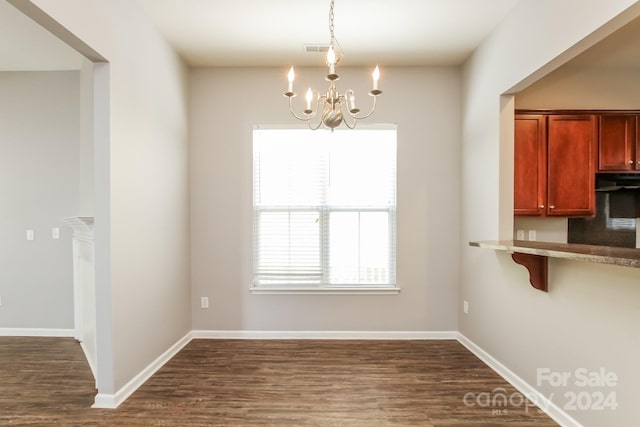 unfurnished dining area featuring dark hardwood / wood-style floors and a chandelier