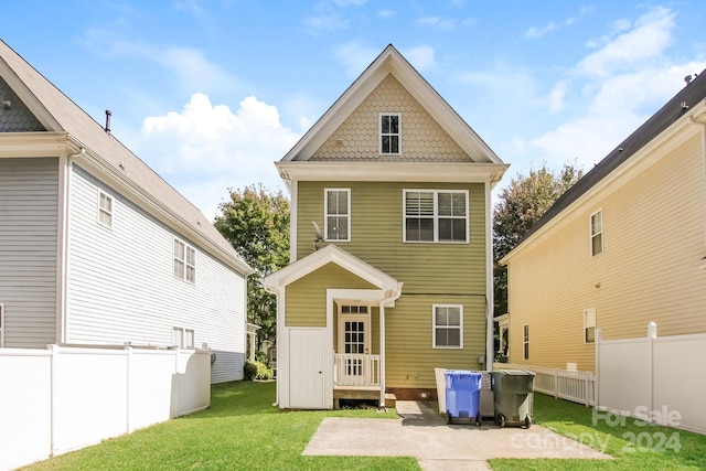 back of house featuring a lawn and a patio