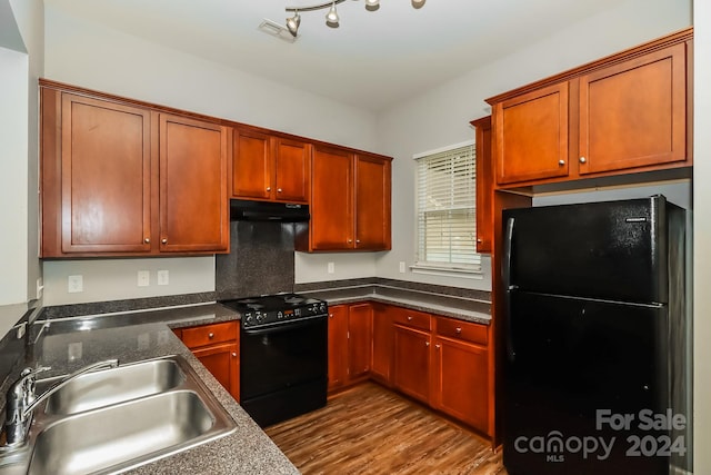 kitchen with light hardwood / wood-style flooring, black appliances, and sink