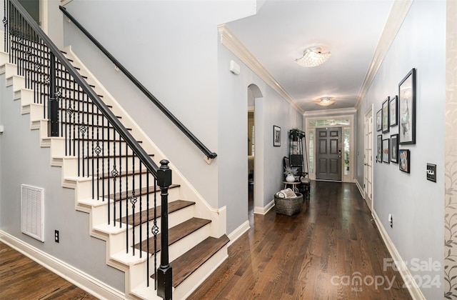 entrance foyer featuring dark wood-type flooring and crown molding