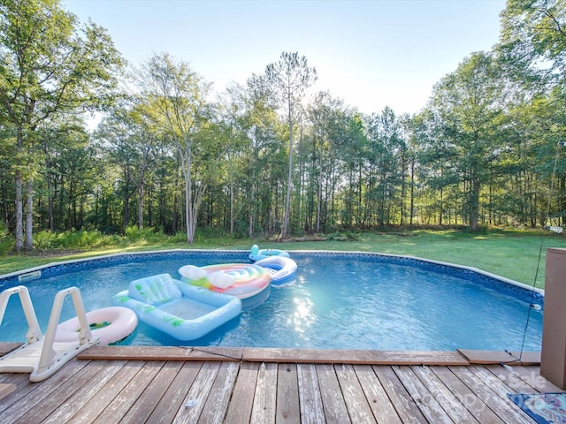 view of swimming pool with a hot tub, a deck, and a lawn