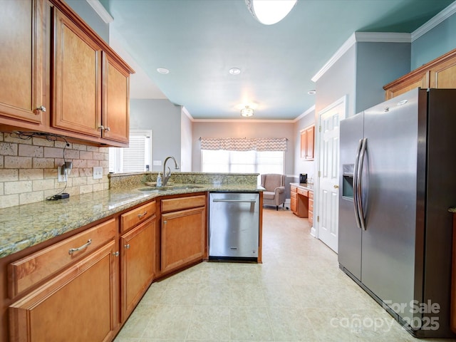 kitchen featuring light stone countertops, appliances with stainless steel finishes, sink, and a wealth of natural light