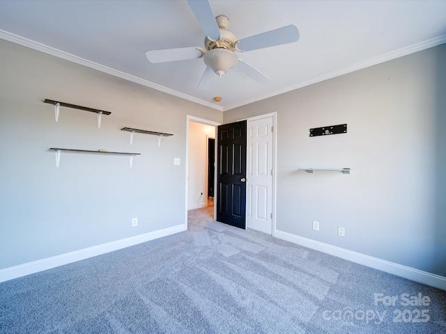 carpeted empty room featuring ceiling fan and ornamental molding