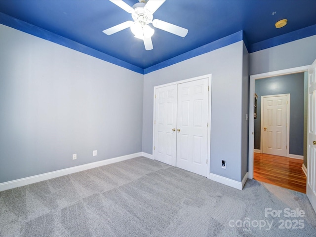 unfurnished bedroom with light carpet, a closet, and ceiling fan