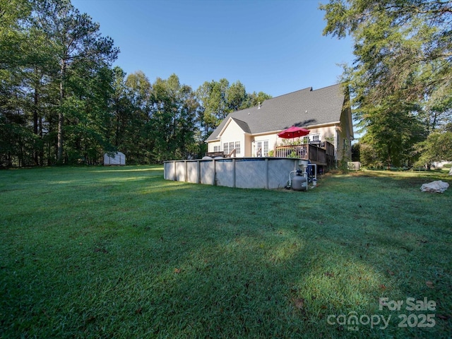 view of yard featuring a pool side deck and a shed