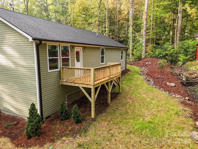 back of property with a yard and a wooden deck