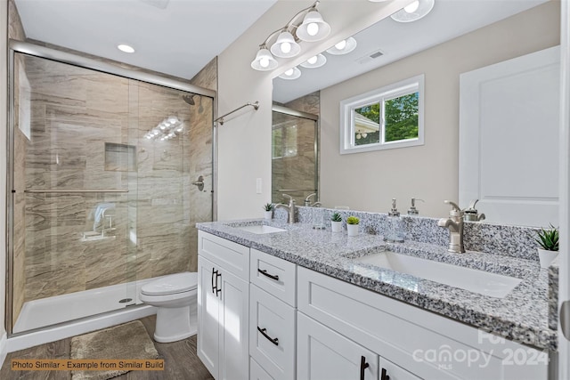 bathroom with vanity, a shower with shower door, toilet, and hardwood / wood-style flooring