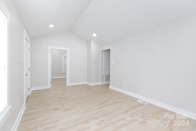 unfurnished room with lofted ceiling and light hardwood / wood-style floors