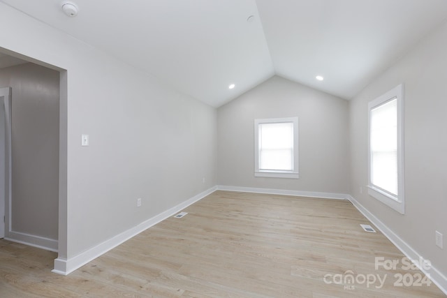 empty room featuring light wood-type flooring and lofted ceiling