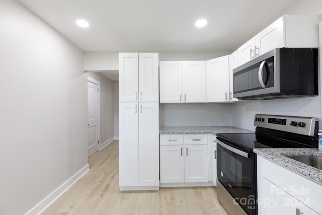 kitchen featuring white cabinetry, light hardwood / wood-style flooring, and stainless steel appliances