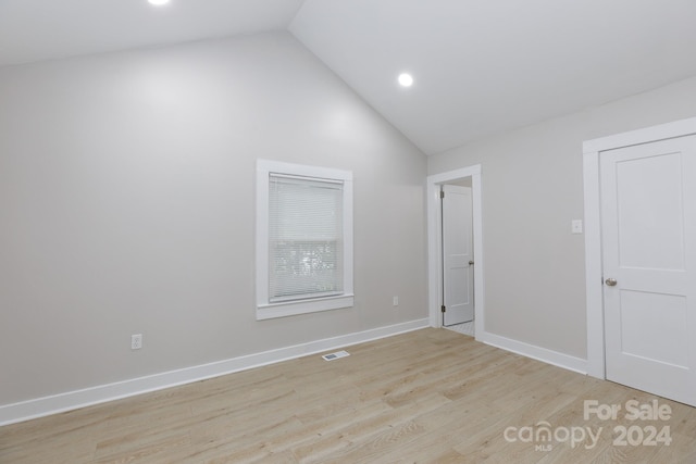 interior space featuring light wood-type flooring and vaulted ceiling