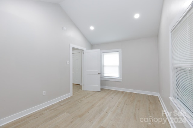 unfurnished room featuring vaulted ceiling and light hardwood / wood-style flooring