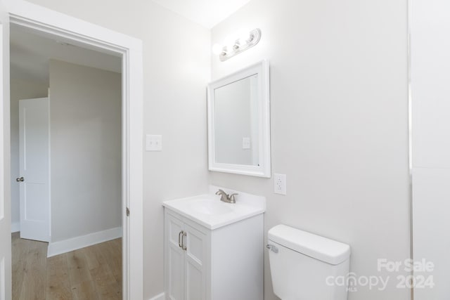 bathroom with vanity, toilet, and hardwood / wood-style flooring