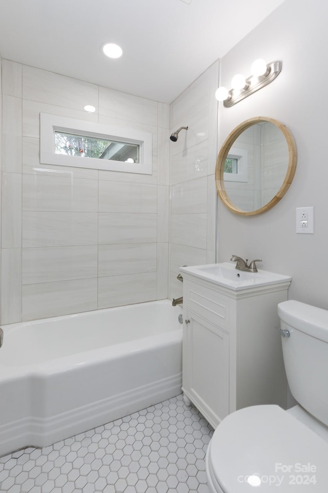 full bathroom featuring tile patterned flooring, toilet, tiled shower / bath combo, and vanity