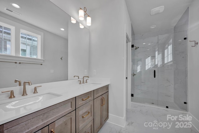 bathroom featuring a shower with door and vanity