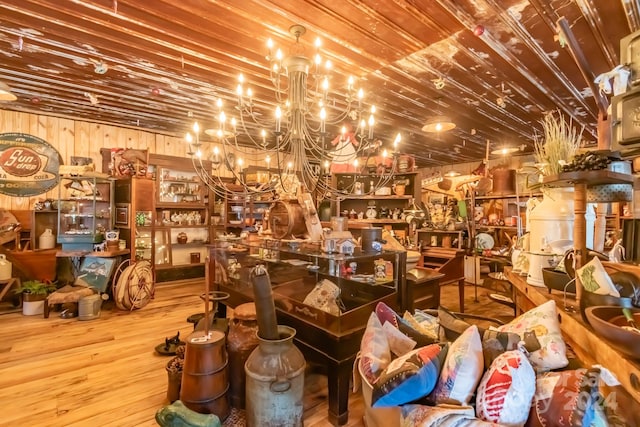 interior space with an inviting chandelier, wooden walls, and hardwood / wood-style flooring