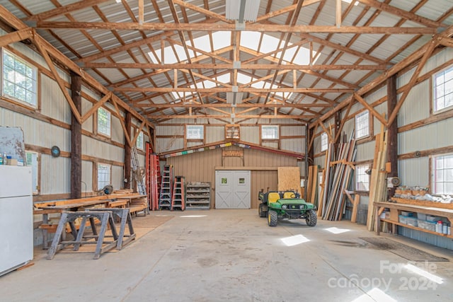 garage with white fridge and a workshop area