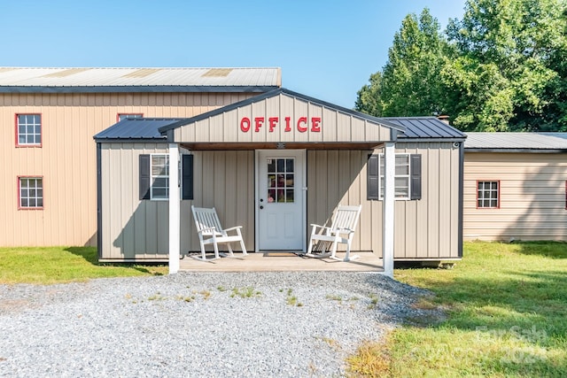 view of outbuilding with a yard and a porch