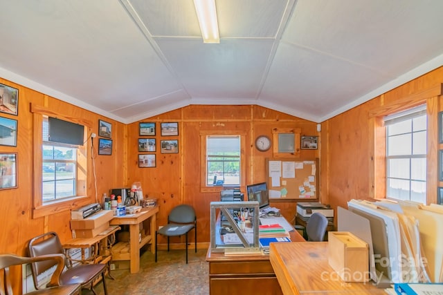 office space featuring lofted ceiling, crown molding, and wooden walls