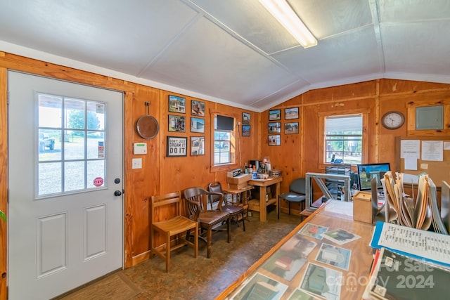 foyer with lofted ceiling and wooden walls