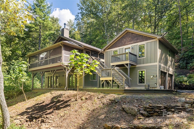 rear view of property with a sunroom and a wooden deck