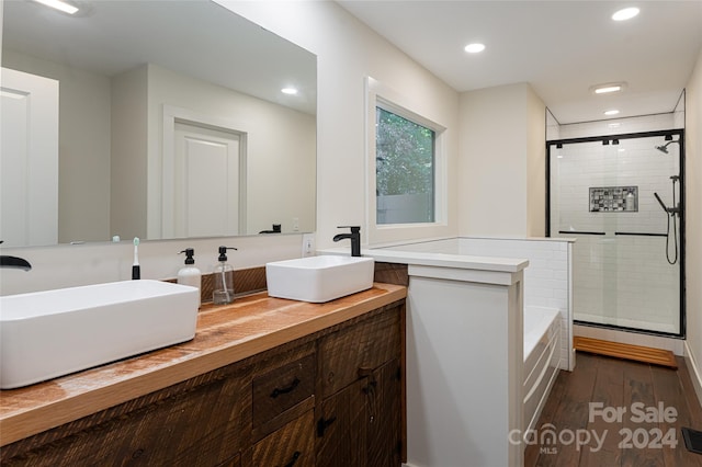 bathroom featuring vanity, independent shower and bath, and wood-type flooring