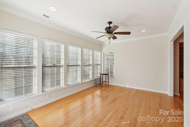 empty room featuring ceiling fan, crown molding, and light hardwood / wood-style flooring