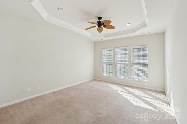 unfurnished room with ornamental molding, ceiling fan, a tray ceiling, and light carpet