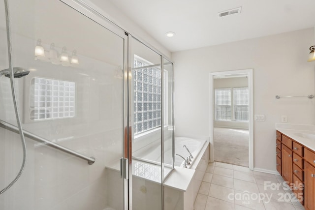 bathroom with tile patterned flooring, shower with separate bathtub, and vanity