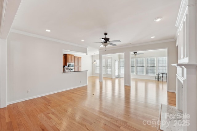 unfurnished living room with ceiling fan, light wood-type flooring, crown molding, and a fireplace