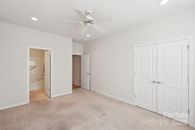 unfurnished bedroom with ensuite bathroom, a closet, ceiling fan, and light colored carpet