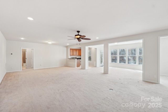 unfurnished living room featuring ceiling fan and light carpet