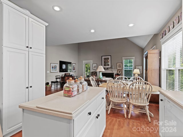 kitchen with white cabinets, light hardwood / wood-style flooring, and a center island