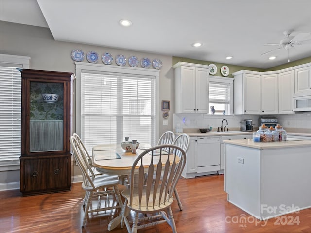 kitchen featuring a healthy amount of sunlight, white appliances, and white cabinetry