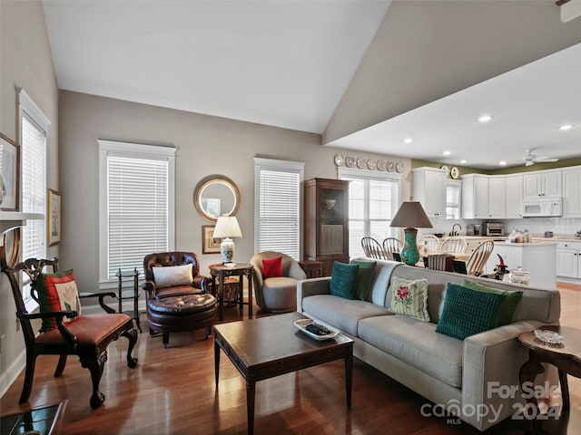 living room featuring wood-type flooring, vaulted ceiling, and ceiling fan