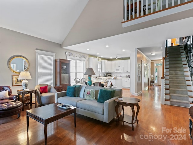 living room featuring light wood-type flooring and high vaulted ceiling