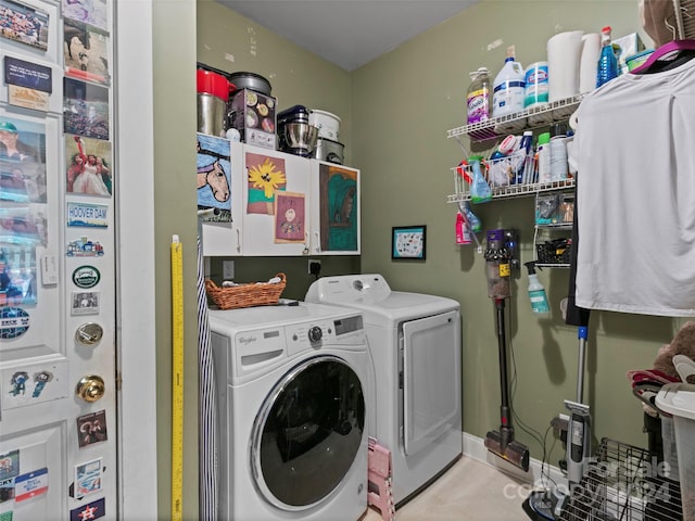 clothes washing area with washing machine and clothes dryer and cabinets