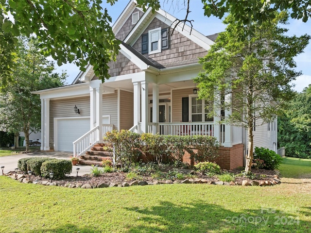 craftsman inspired home with a front lawn, a porch, and a garage