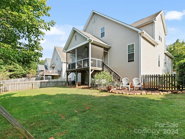 rear view of house featuring a lawn and a sunroom