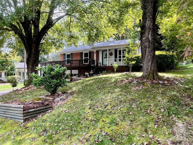 ranch-style house featuring a front lawn and a wooden deck