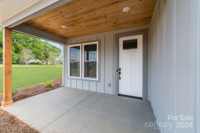 doorway to property with a patio area and a lawn